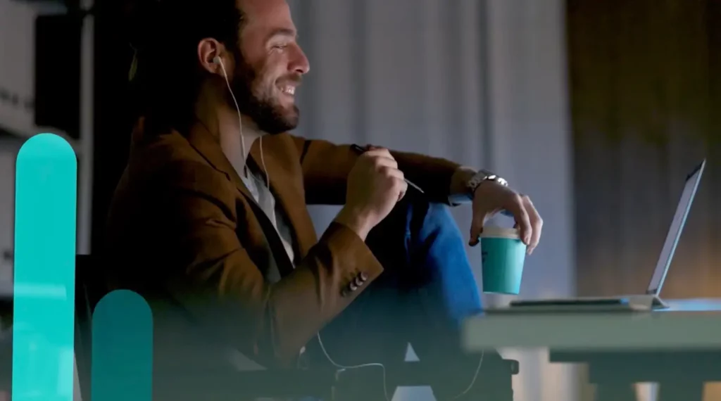 A man is sitting in front of a laptop with headphones on, attending a LIVE 2023 SEO webinar.